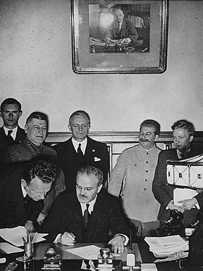 The German foreign minister, Joachim von Ribbentrop (third from right), watches his Soviet counterpart Vyacheslav Molotov (seated) sign the Molotov-Ribbentrop Pact of non-aggression on Aug. 23, 1939. AP Photo