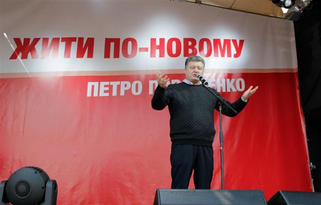 President Poroshenko stands on the backdrop of his electoral slogan, Zhyty po-novomu [Living the new way]