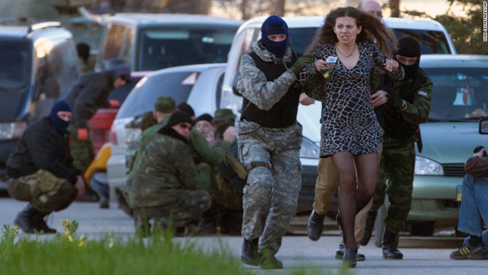 Russian special forces and mercenaries subdue and escort away a local resident before Russian troops assault the Ukrainian Belbek airbase, outside Sevastopol, Crimea, on March 22, 2014. (Image: AP Photo/Ivan Sekretarev)