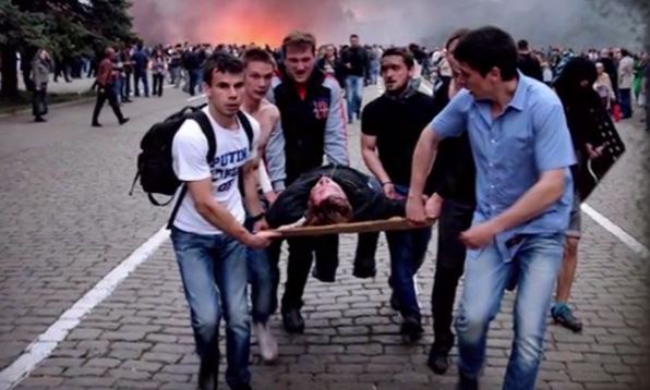 Euromaidan activists help evacuate Antimaidan survivors of the fire. Photo by Oleh Kutskyi, shapshot from video (46:50)