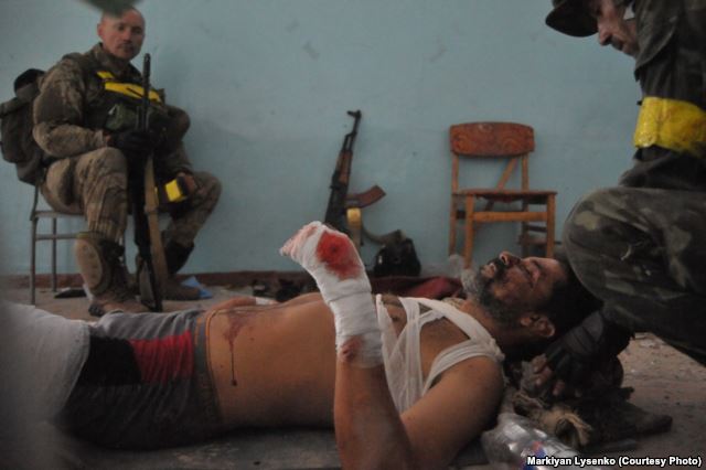Ukrainian soldiers are bandaging their wounded commander Photo: Markiyan Lysenko