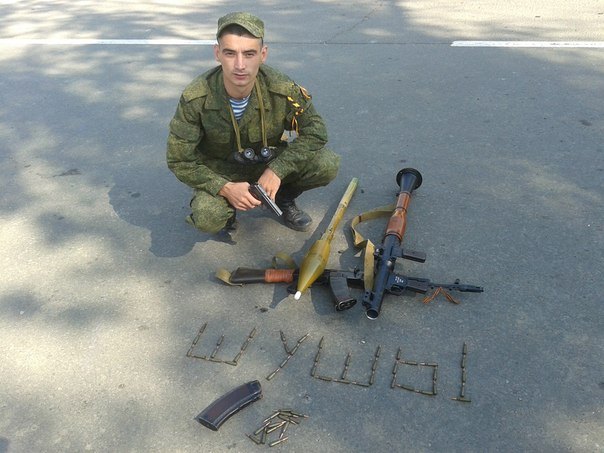 Gritsyuk posing with weapons, spelling out "" with bullets