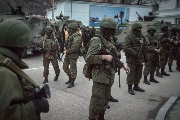 Armed Russian soldiers block the entrance to a Ukrainian naval border guard base in Sevastopol during the annexation of the Crimea region of Ukraine. March 2014. (Image: New York Times)
