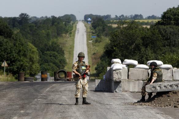 REUTERS//Valentyn Ogirenko Photo: A Ukrainian serviceman guards a checkpoint in the town of Debaltseve in Donetsk region August 2, 2014.