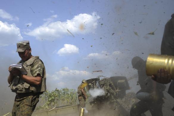 REUTERS/Maks Levin Photo: Ukrainian servicemen, who are members of an artillery section, take cover after firing a cannon during a military operation against pro-Russian separatists near Pervomaisk, Luhansk region August 2, 2014.