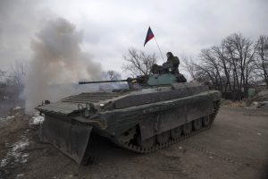 Fighters with the separatist self-proclaimed Donetsk People's Republic army sit on top of a moving armoured personnel carrier at a check point on the road from the town of Vuhlehirsk to Debaltseve