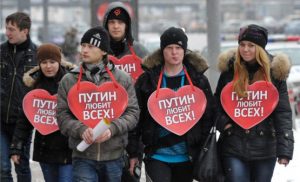 Russian youths wearing signs "Putin loves everyone!" (Photo: nr2.com.ua)