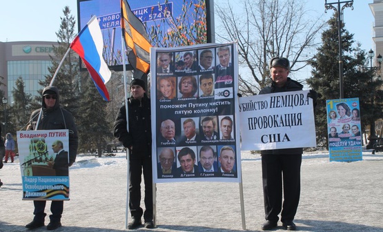 Russians supporting Putin's policies hold anti-opposition and anti-US signs