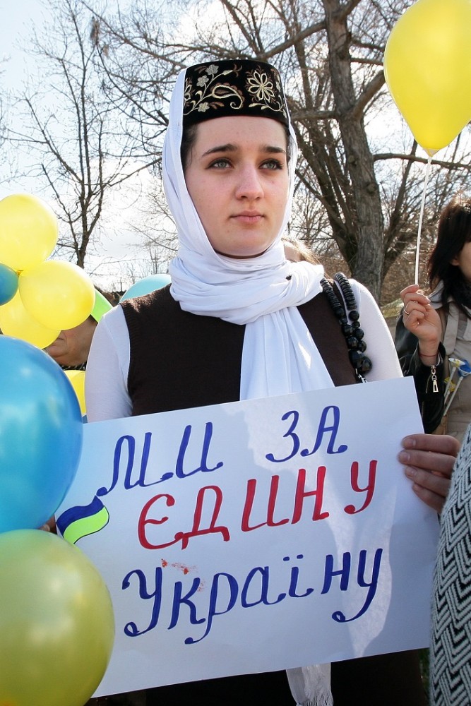 A girl in a national Crimean Tatar dress holds a placard during a protest against the presence of Russian troops in Crimea, Bakhchysaray, Crimea, March 5, 2014 (Image: mfa.gov.ua)