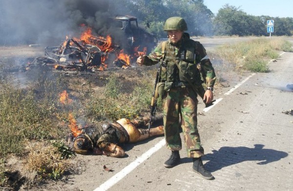 Russian neo-Nazi mercenary Alexey Milchakov photographed next to the corpse of a tortured Ukrainian soldier after an ambush on his vehicle. Donbas, Ukraine (Image: Milchakov's social network page)