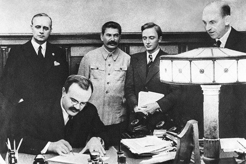 Stalin supervising the signing of the so-called Molotov-Ribbentrop Pact dividing Poland between Hitler's regime and his own, Aug 23, 1939. From left to right: Joachim von Ribbentrop, German Minister of Foreign Affairs; Vyacheslav Molotov, Soviet Minister of Foreign Affairs (sitting); Joseph Stalin, Soviet dictator; Vladimir Pavlov, First Secretary of the Soviet embassy in Germany (Image: TASS)