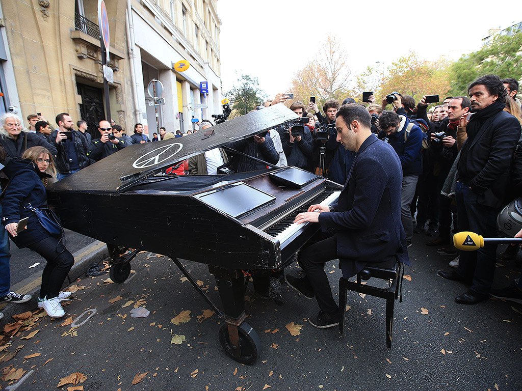 An unnamed man brings his portable grand piano and plays John Lennon's "Imagine" by the Bataclan, a Parisian concert hall. (Image: John Walton / PA Wire)