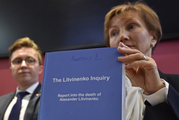 Marina Litvinenko holding the report of the British judicial investigation into the death of her husband Alexander Litvinenko next to their son Anatoly (Image: Reuters)