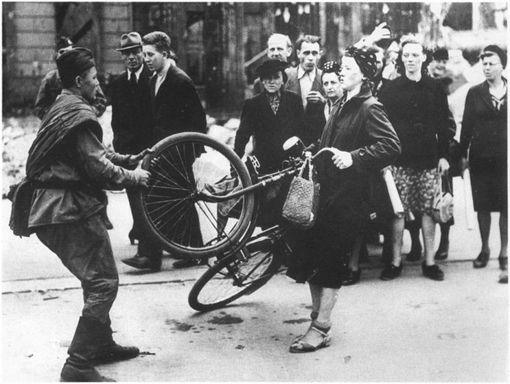 This photo, taken in August of 1945 in Berlin, was printed in the Life magazine with the caption “A Soviet soldier conflicts with a woman over a bicycle that he wanted to purchase from her” ~