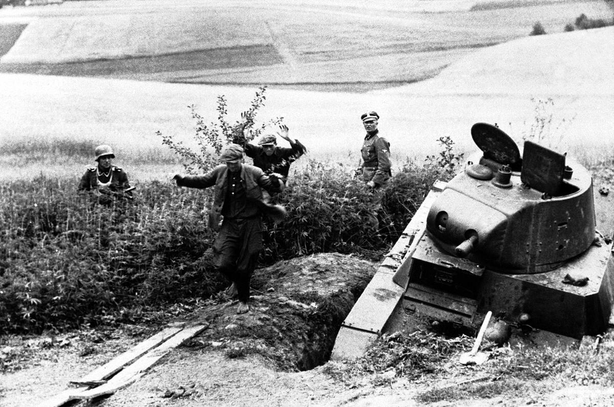 Soviet snipers leave their hide-out in a wheat field, somewhere in the USSR, on August 27, 1941, watched by German soldiers. In foreground is a disabled soviet tank. (Image: AP)