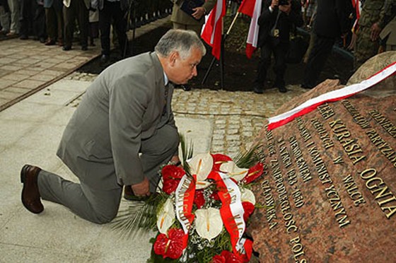 Ex-president of Poland Lech Kaczynski kneels before the monument to Jozef Kuras.
