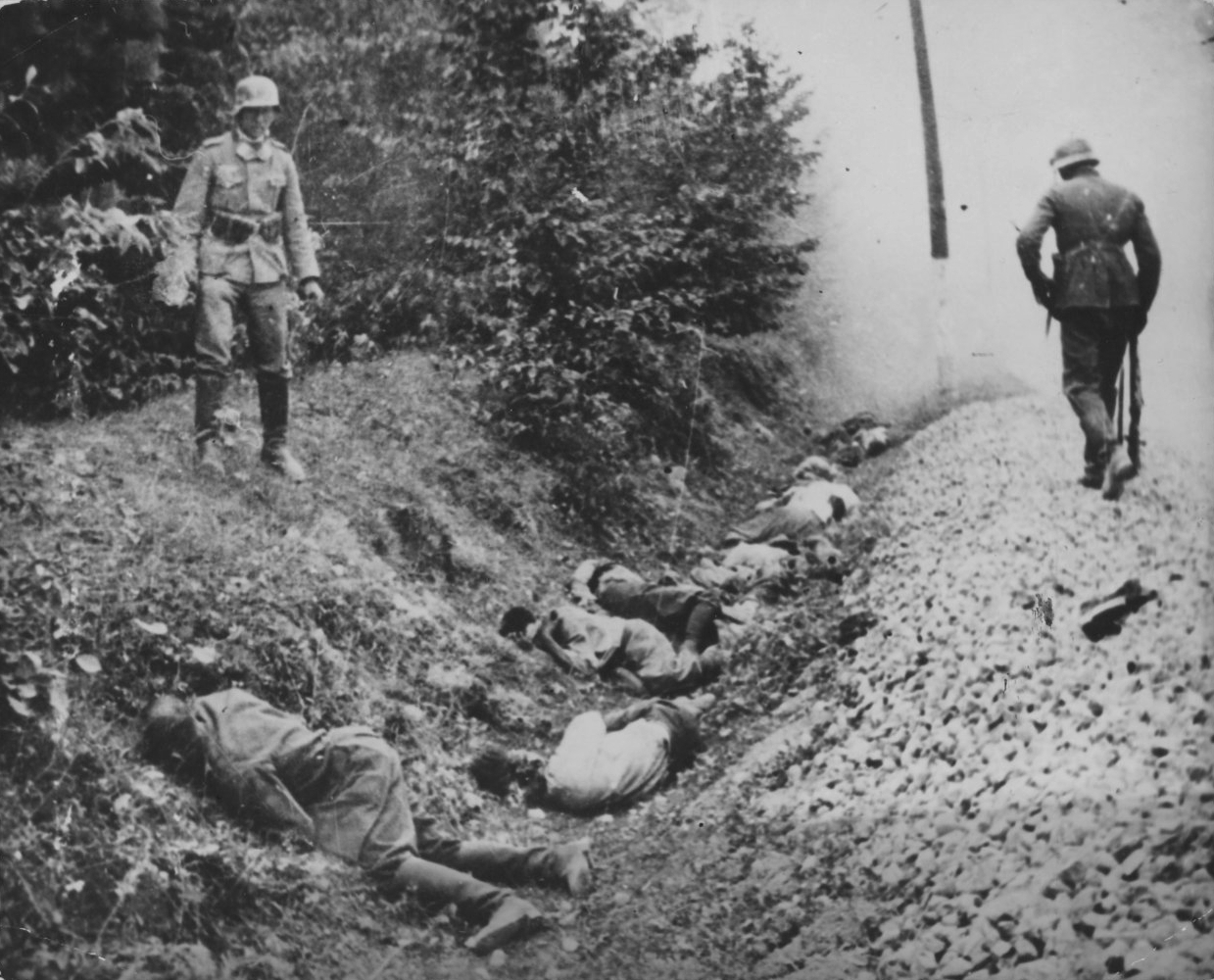 Two German soldiers near the ditch with bodies of executed Poles, Sept.-Oct. 1939 (Image: nationaalarchief.nl)