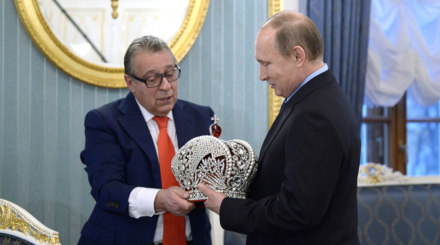 Gennady Khazanov, an acclaimed Russian comedic actor loyal to the Putin regime, presenting the Russian president with a reproduction of the Russian imperial crown made for Putin's 63rd birthday. (Image: meduza.io)
