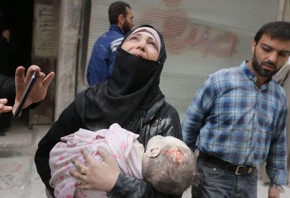 A Syrian woman carries the body of her infant after he was retrieved from under the rubble of a building following a reported airstrike on September 23, 2016, on the al-Muasalat area in the northern Syrian city of Aleppo. (Image: AFP / THAER)