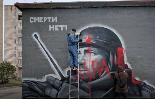 When Putin's propaganda machine quickly started spinning to capitalize on Motorola's death by painting murals in his honor, in St.Petersburg, an unknown wrote the word "Scum" on one of them. (Image: social media)