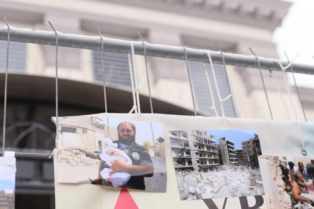 Photos of destroyed Syria were taped over the fence of the embassy. Photo: 