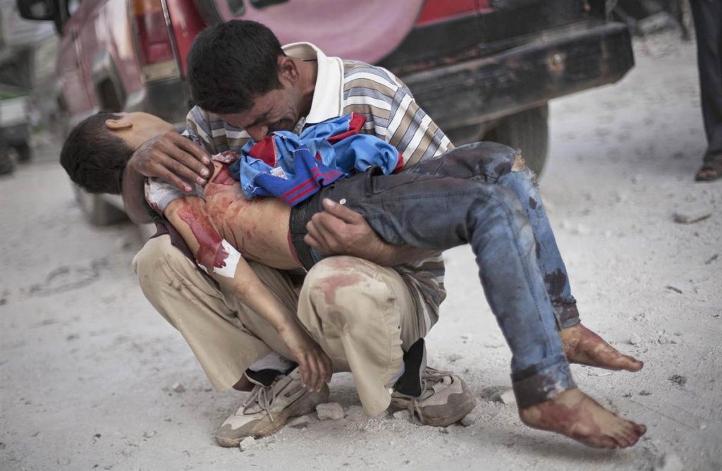 A Syrian man cries while holding the body of his son near Dar El Shifa hospital in Aleppo, Oct. 3, 2016. (Image: Manu Brabo / AP)