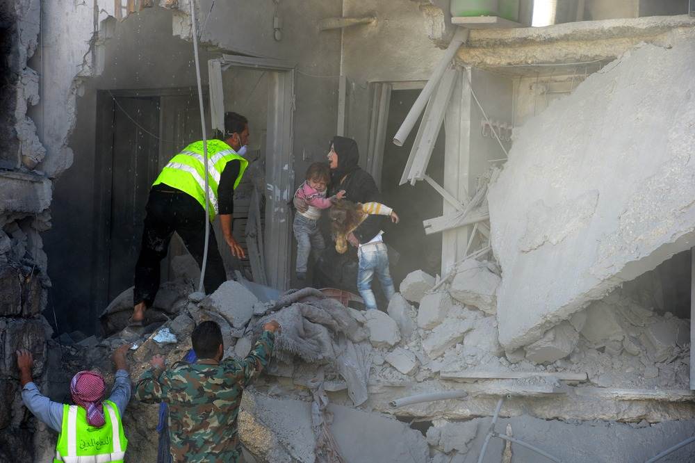 Syrian rescue workers evacuate a woman and her two children from a building targeted by a government forces air strike on the northern Syrian town of al-Bab, northeast of Aleppo on Nov. 4, 2016 (Image: Philippe Desmazes / AFP)