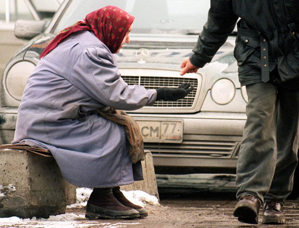 An old woman begging next to a Mercedes-Benz car in Moscow. While the Russian capital of Russia has the most billionaires - 79, poverty is widespread. By official estimates, 13% of Russians (18.5 million people) live below the poverty line. (ALEXANDER NEMENOV/AFP/Getty Images)