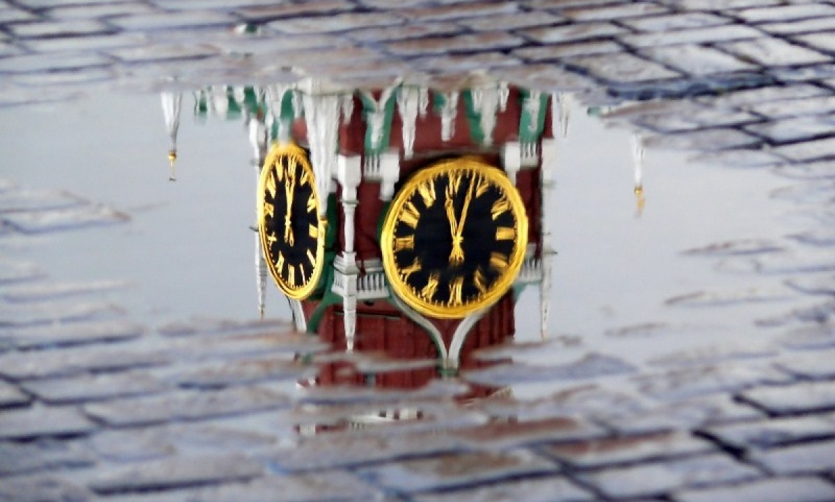 Main Kremlin tower reflected in a puddle on the Moscow Red Square ~