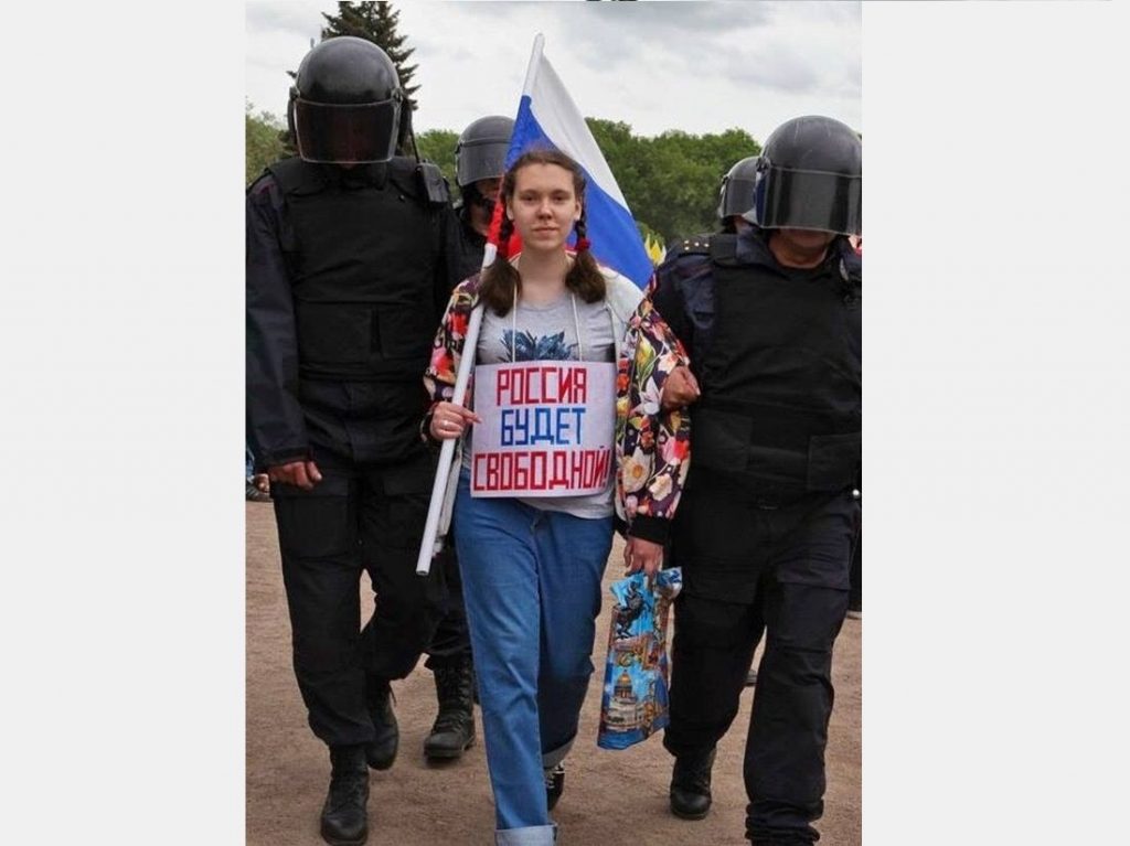 The sign on the woman's chest says: "Russia Will Be Free!"