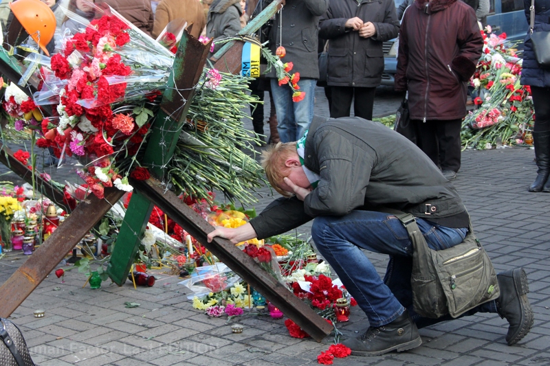 A man kneels at a memorial to protesters killed during the Euromaidan revolution, the “Heaven’s Hundred.” Photo: Viktor Gurniak. 24 February 2014. From the project Human Factor: Last Edition ~