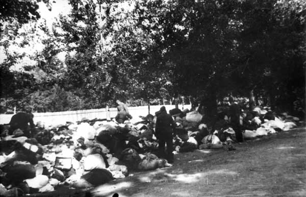German soldiers dig into the belongings of the Jews shot in Babi Yar. Vul. Simyi Khokhlovykh on 29 September 1941. Photo: Babi Yar Committee official site ~