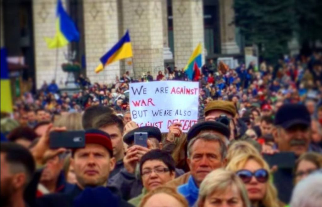 “We are against war, but we are also against defeat,” reads the placard held by a participant of the “Let’s Stop Capitulation” rally in Kyiv on 6 October 2019. Photo: Dmytro Karpiy/Facebook ~