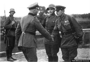 German and Soviet officers shake hands to “celebrate” the invasion of Poland, fall of 1939. Photo published in September 1940 in Krasnaya Zvezda newspaper on the first anniversary of the partition of Poland between Germany and the USSR. Photo: TASS, Wikipedia Commons ~