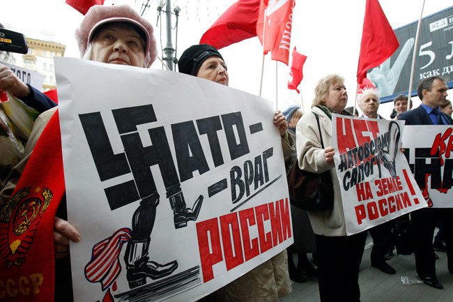 A woman holds a sign saying “NATO is Russias enemy” at a protest in Ulyanovsk in 2012. Photo: Infox.ru ~