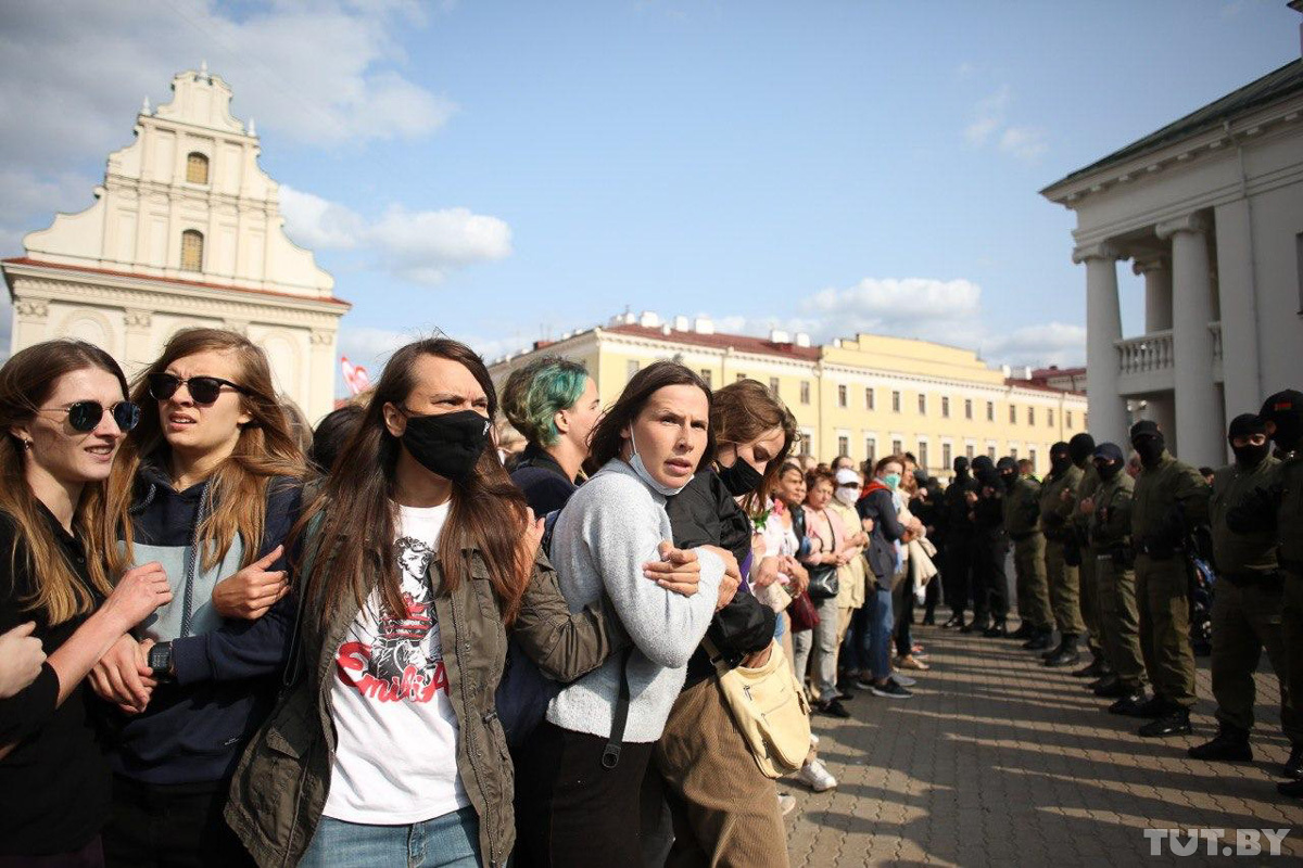 Women link arms facing off the riot police. Photo: Vadim Zamirovskyi, tut.by ~