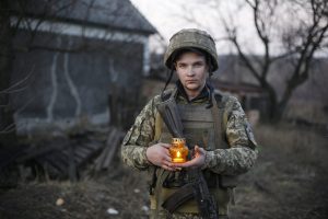 Vasyl, 20 years old, from Ivano-Frankivsk Oblast. Vasyl holds the Bethlehem Fire of Peace, which was brought to the front line by volunteers. Deployed near Popasna, Luhansk Oblast, December 28, 2017. After being wounded in the neck by an 8-millimeter AGS fragment, Vasyl returned to the front. ~