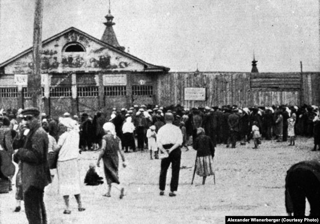 “The bread queue at the Kharkiv bazaar in 1933. On the pediment of the closed shop, as a mockery, there is a picture of juicy fruits that were sold here”(author’s caption). In the photo: Blahovishchenskyy Bazaar (officially named the Central Communal Market) in the center of Kharkiv. The market was completely destroyed during World War II. Photo by Alexander Wienerberger, illustration from the book “Hart auf hart. 15 Jahre Ingenieur in Sowjetrußland. Ein Tatsachenbericht, Salzburg 1939» ~