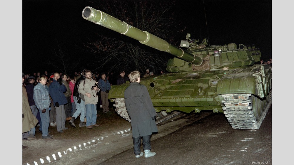 A peaceful protester standing in front of a Soviet tank in Vilnius, Lithuania in January 1991 ~
