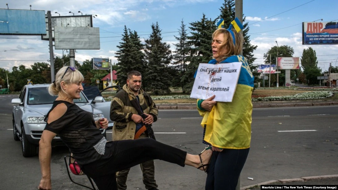 25 August 2014, occupied Donetsk. Pro-Ukrainian activist Iryna Dovhan, tied to a stake, is being beaten by passers-by Photo by Mauricio Lima for New York Times. ~