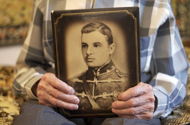 Dmytro Vynirskyi holds the portrait of his father, Denys Vyniarskyi, taken in time of his father’s service in the army. Photo: Holodomor museum ~
