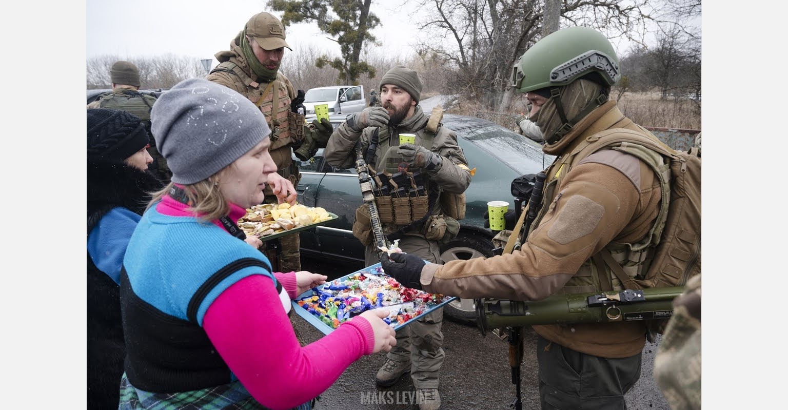 Residents of a Ukrainian town offering food and hot drinks to the soldiers defending their town. Russo-Ukrainian War. March 2022 (Photo: Maks Levin)
