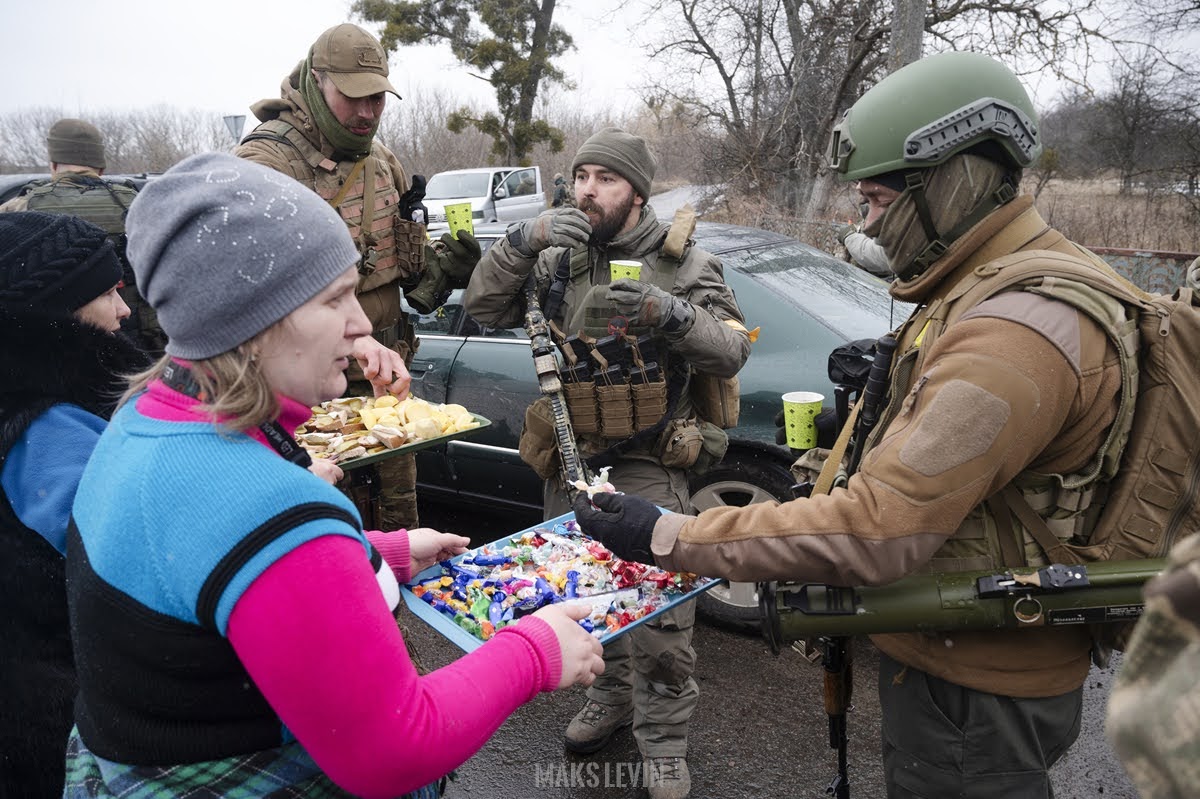 Residents of a Ukrainian town offering food and hot drinks to the soldiers defending their town. Russo-Ukrainian War. March 2022 (Photo: Maks Levin)