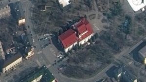 The Mariupol Drama Theater before it was bombed by Russian airplanes. Two giant white signs with the Russian word for "children" are visible on the opposite sides of the building. Satellite photo by Maxar Technologies