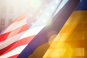 Ukrainian and American flags in the sunlight.