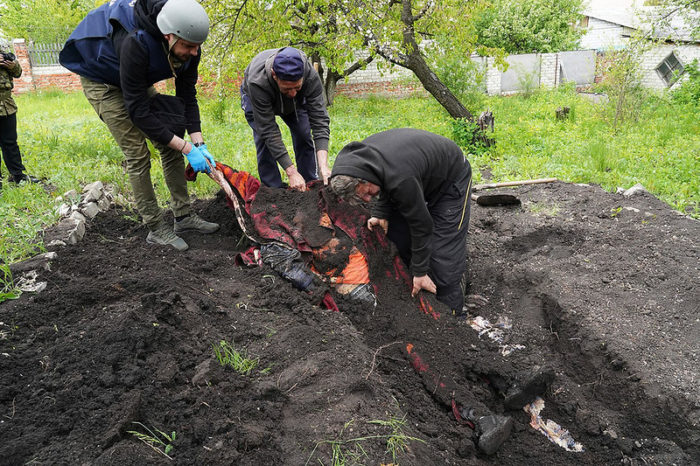 police and volunteers exhume bodies Stepaky village Kharkiv Oblast