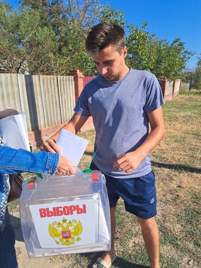 A man places a "ballot" into a box on the street in a residential area in Russian-occupied Henichesk, Kherson Oblast, 6 September 2023: Kherson Oblast Election Commission/Telegram