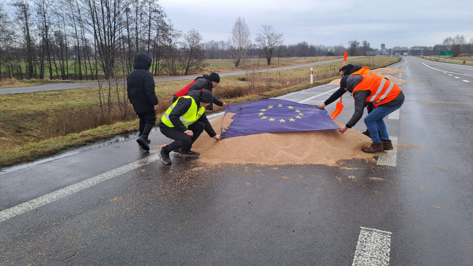 Protesting Polish farmers covering the grain spilled from Ukrainian trucks with the EU flag near Dorohusk, Poland. 11 February 2024. Photo: farmer.pl/Monika Chlebosz