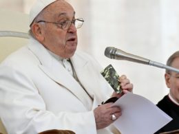 Pope Francis holding the rosary and the camouflaged New Testament book of a young Ukrainian soldier killed in the war during his general audience