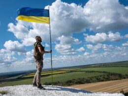 Ukrainian soldier near a Ukrainian flag